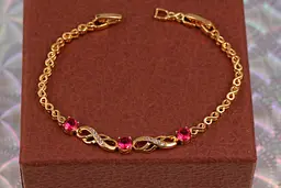 Браслет Xuping Jewelry вісімки з трьома круглими малиновими каменями у центрі 17 см 6 мм золотистий